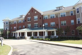 a large brick building with a porch and a driveway
