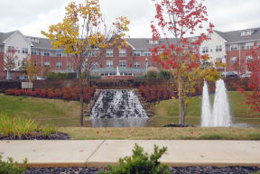 a fountain in a garden in front of a building