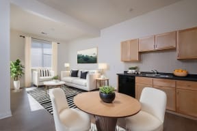 a living room and kitchen with a table and chairs at Cornerstone Village