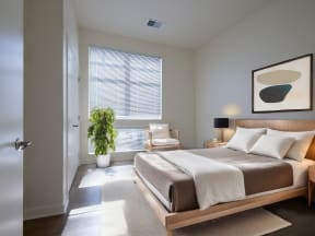 a bedroom with a large bed and a window at Cornerstone Village Apartments