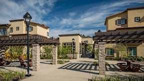 Entrance to courtyard, with trellis and columns and picnic tables-Parque Vista, Los Angeles, CA