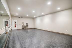 A spacious room with a grey floor and white walls.