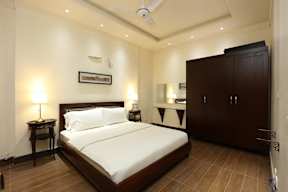A bedroom with a bed, nightstands, and a cabinet.