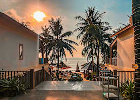 A sunset view from a balcony overlooking the ocean.