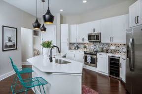 a large kitchen with white cabinets and a sink