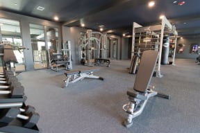 a gym with weights and other equipment in a building with glass doors