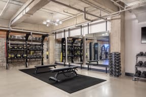 a gym with weights and dumbbells in a loft space
