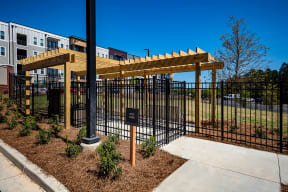 a black fence with a wooden pergola in front of a building