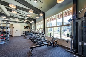 a room filled with cardio equipment and large windows