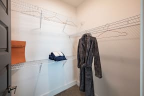 a walk in closet with a robe hanging on the wall