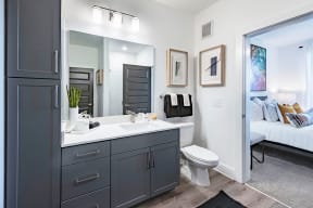 a bathroom with gray cabinets and a white countertop