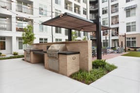 a bbq area with an apartment building in the background