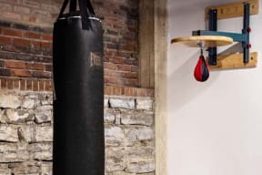 a punching bag hanging from a brick wall next to a punching ball on a rack
