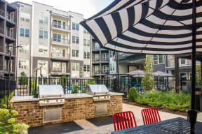 our apartments have a large outdoor patio with a grill and an umbrella