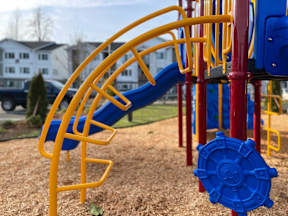 a playground with a blue and yellow spiral slide at Pottery Creek Apartments, Port Orchard Washington