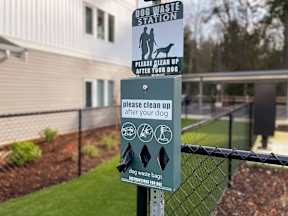a sign on a fence in front of a dog waste station at Pottery Creek Apartments, Port Orchard, WA