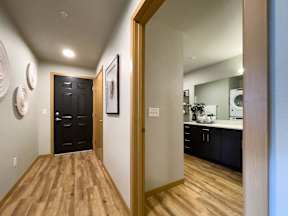 a hallway with a door to a kitchen and a mirror at Pottery Creek Apartments, Port Orchard, 98366