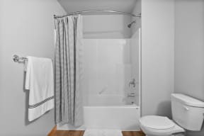 a white bathroom with a shower and a toilet