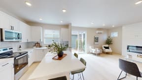 a kitchen and dining room with white cabinets and a white table