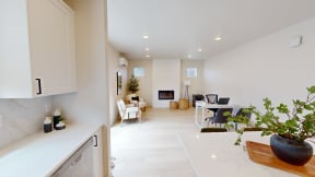 a kitchen and living room with a desk and a fireplace