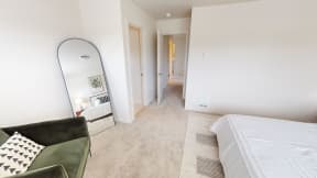 a bedroom with a large mirror and a couch and a bed