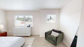 a bedroom with a bed and a chair and two windows