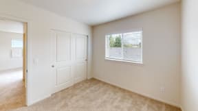 an empty bedroom with a door and a window