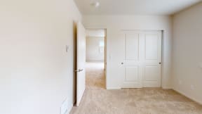 a bedroom with a closet and a door to a hallway