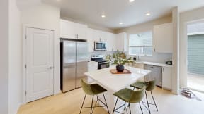 a kitchen with a white counter top and a stainless steel refrigerator