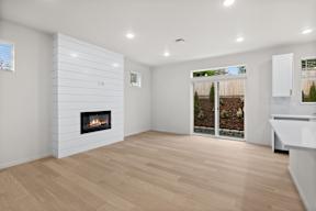 A modern living room with a fireplace and wooden flooring.