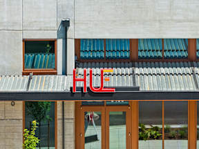 the facade of a building with a sign on it at Hue Apartments, Redmond , Washington