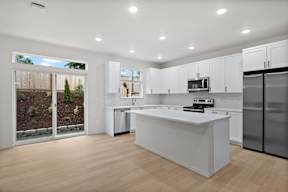 A modern kitchen with white cabinets and a central island.