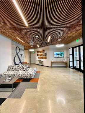 A modern waiting room with a wooden ceiling and a couch.