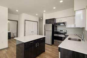 A modern kitchen with dark wood cabinets and stainless steel appliances.