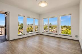 A room with a view of a residential area through the windows.