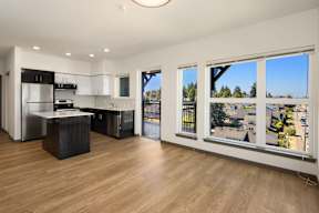 A modern kitchen with wooden floors and a view of the city.