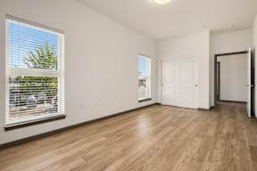 A room with a window and wooden flooring.