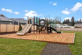 A playground with a slide and a green railing.