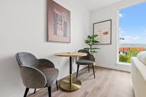 a living room with two chairs and a table and a window at Hue Apartments, Redmond , Washington