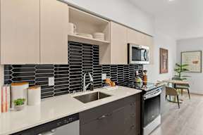 a kitchen with a sink and a stove and a microwave at Hue Apartments, Redmond , Washington