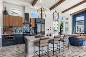 A modern kitchen with a large island and bar stools.