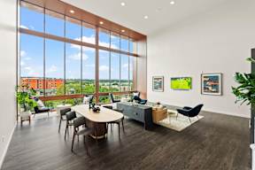 a living room with a large window and a table and chairs at Hue Apartments, Washington, 98052
