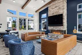 A modern living room with a stone fireplace and a flat screen TV mounted on the wall.