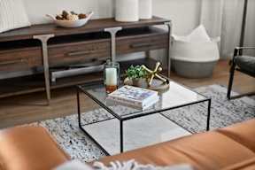 A living room with a coffee table, a couch, and a bowl of nuts.