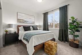 A bedroom with a large bed and a painting on the wall.