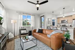 A living room with a brown leather couch and a glass coffee table.