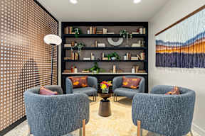 a living room with chairs and a book shelf at Hue Apartments, Redmond , Washington