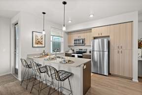 A modern kitchen with a large island and stainless steel appliances.