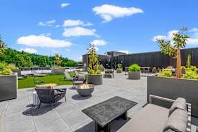 a rooftop patio with tables and chairs and plants at Hue Apartments, Redmond , WA