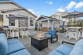 A patio with a fire pit and seating area.